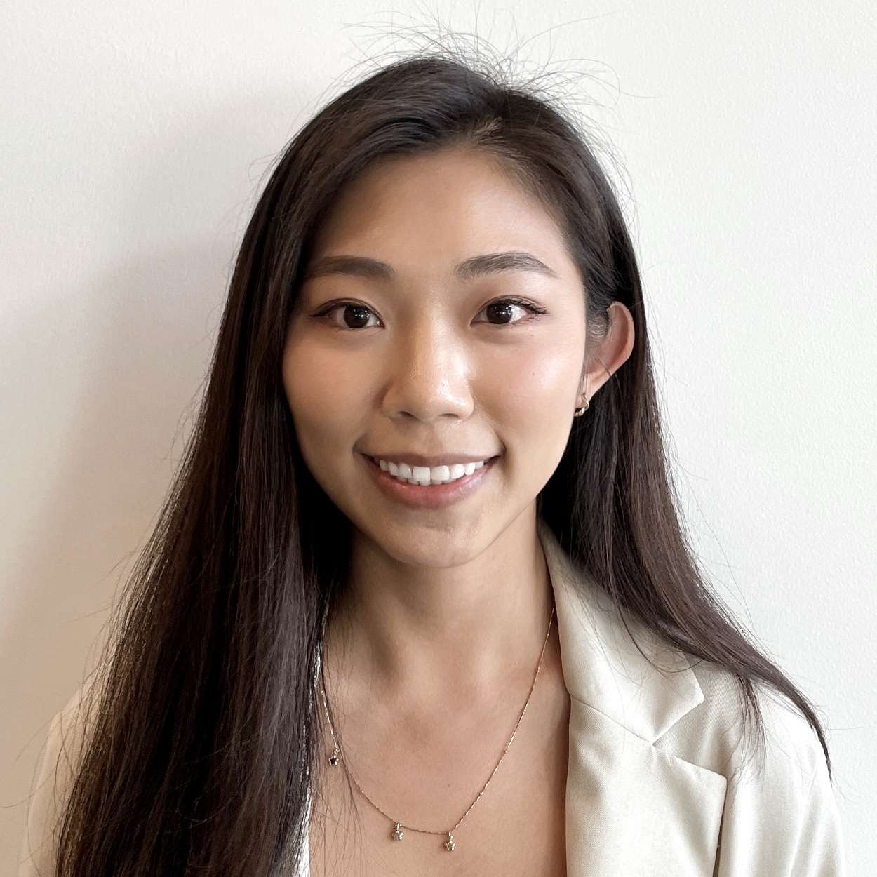 Female smiling, with long dark hair, wearing being blazer